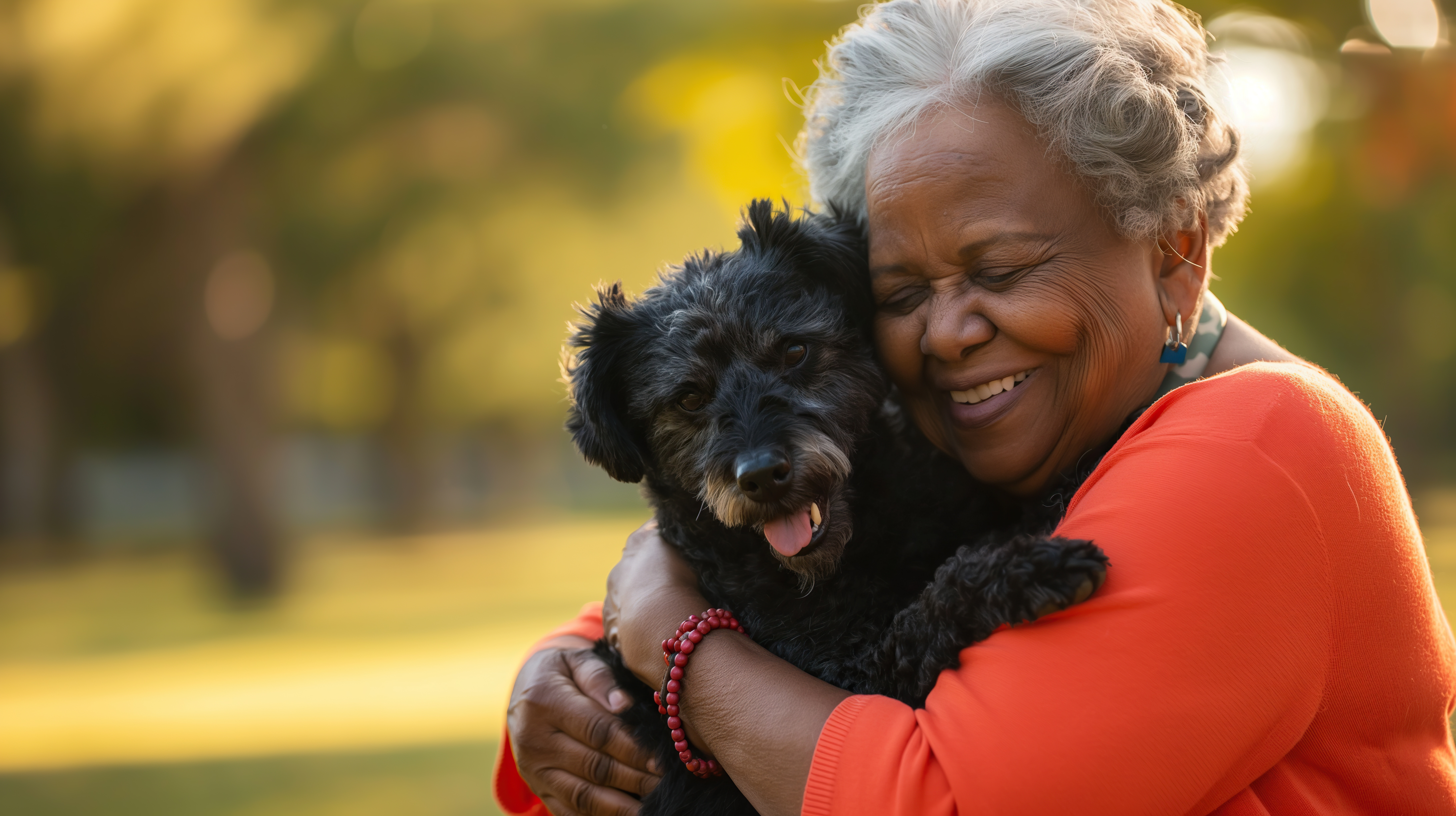 An older adult woman sits happily with her small dog in a cozy living room, showing the joy and companionship pets bring to seniors.