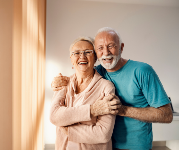 Smiling senior couple embracing at home, symbolizing independence, comfort, and compassionate care through alice.care.